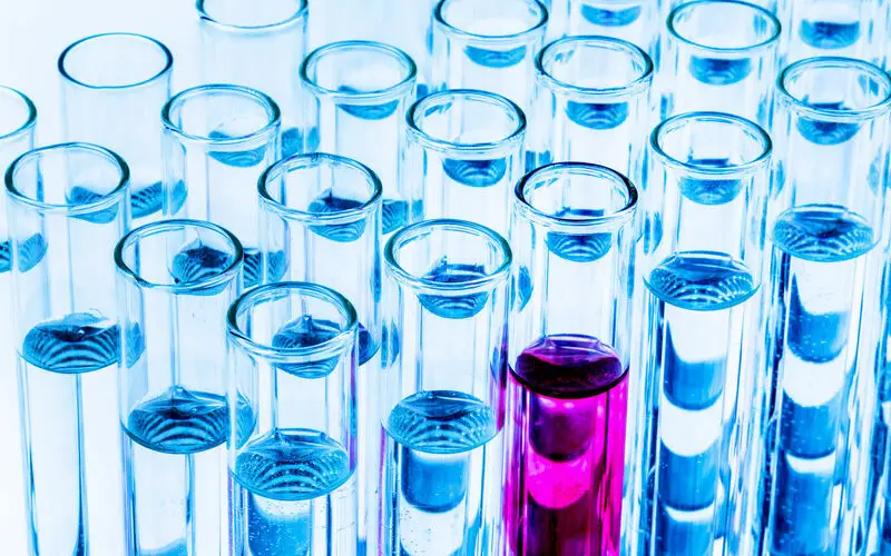 many clear test tubes with one pink one showing how keywords can be useful for writing focused affiliate articles