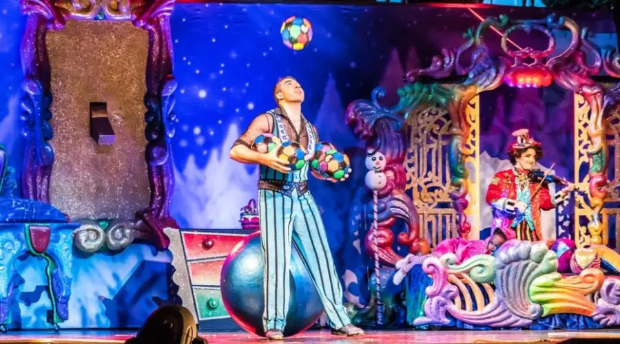 The image shows a stage performance featuring professioanl backdrops, a juggler and a musician, representing just three sectors (art, talent, live music) within the larger live entertainment industry.